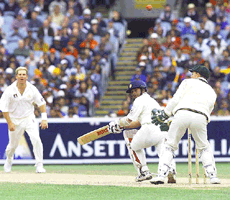 Australian bowler Shane Warne (left) looks on as Indian batsman Sachin Tendulkar hooks one of his balls down towards the boundary in the morning session of the final days play of the Boxing Day Test between Australian and India at the Melbourne Cricket Ground on Thursday