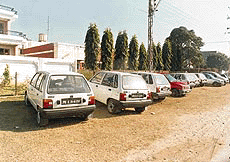 Cars parked along the boundary walls of homes near marriage palaces