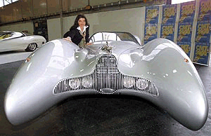 Model Bibi strokes over the fender of a Horch-Colani convertible in Stuttgart, Germany on Wednesday, during a press conference for the CMT 2000, an international exhibition for caravaning, motoring and tourism which will be held here from Jan. 15 to 23. Besides this Horch-Colani convertible the CMT 2000 shows three other cars designed by Luigi Colani.