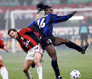 Inter's Dutch midfielder Clarence Seedorf, right, challenges for the ball with A.C. Milan's Andres Guglielminpietro of Argentina during Italy cup, first leg, quarter final match at the San Siro stadium in Milan, Italy on Wednesday