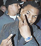 US boxer Mike Tyson points to his new Graff watch in a store at London's New Bond Street where he reportedly spent $ 1.8 million.