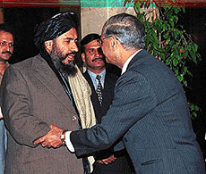 Taliban acting President Mulla Mohammad Rabbani, left, being received by Pakistan Foreign Ministar Abdul Sattar at a hotel in Islamabad on Monday. Rabbani leads a 18-member delegation to hold talks with Pakistani officials on bilateral and regional issues of mutual interest. Man in the cener is unidentified
