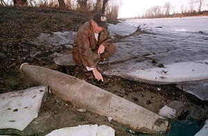 A man points at an unexploded NATO bomb on the bank of the Danube river, near the downed "Liberty" bridge in Novi Sad, some 80 km northwest of Belgrade on Wednesday