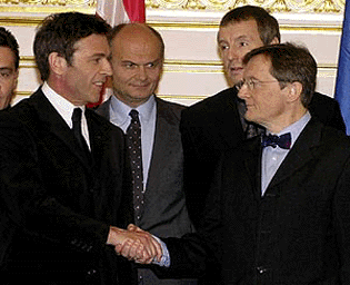 Leader of the rightwing Freedom Party Joerg Haider, left, and Head of the Austrian People's Party Wolfgang Schuessel, right, shake hands after signing their programme for a new government as Thomas Prinzhorn of the Freedom Party, 2nd from left, and Martin Bartenstein of the people's Party, 2nd from right, look on, at Vienna's Hofburg Palace on Thursday