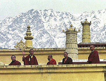 The 17th Karmapa, Urgyen Trinley Dorje, waves to visitors from atop the Gyuto Ramoche Monastery with the Himalayas as a backdrop near Dharmshala, Friday. The Karmapa escaped from Chinese occupied Tibet in January and has been living at the monastery since. In an audience on Friday on the eve of the Tibetan New Year, the Karmapa said that Tibetan Buddhists need freedom in order to practice their religion