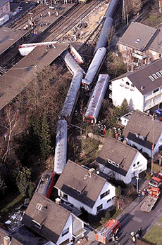 An aerial view taken from a helicopter shows the scene where an European overnight train hurtled off the tracks and smashed through a garage and into a house at Bruehl station, near Cologne, western Germany, early Sunday, killing at least six people aboard and injuring more than 100, including about 20 seriously, authorities said. One car went down an embankment and another was crushed against a steel post as the sleeper train, heading from Amsterdam, the Netherlands, to Basel, Switzerland, with about 300 passengers, derailed shortly after midnight at a switch in a Cologne suburb, said German railways spokesman Manfred Ziegerath
