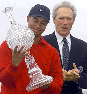 Tiger Woods of Orlando, Florida, looks at his latest trophy as actor Clint Eastwood looks on after winning the AT&T Pebble Beach National Pro-Am in Pebble Beach, Monday. The win was Woods' sixth consecutive PGA Tour victory