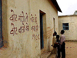 A polling station in a central Bihar village with wall writing of boycott call by Maoist Communist Centre, extremist organisation, threatening the voters with dire consequences