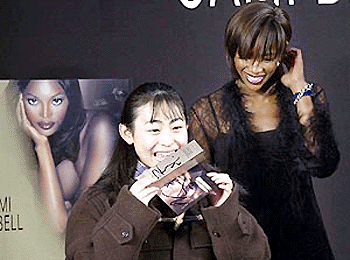 Naomi Campbell, right, smiles at a Japanese girl reacting after receiving the British supermodel's signature perfume at a promotion event in Tokyo's Shibuya commercial district on Monday. More than 500 fans turned out to have a glimpse of the charismatic figure among the fashion conscious Japanese youth. 