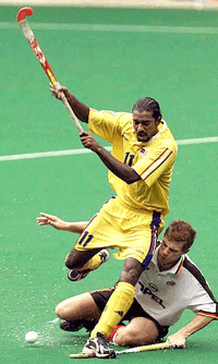 Kaliwaran Muniady of Malaysia, in yellow, vies for the ball with Bjorn Emmerling of Germany during their match of the 10th Sultan Azlan Shah Cup men's hockey tournament in Kuala Lumpur on Thursday