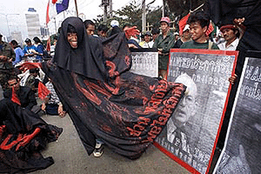 A protester dressed as the "Grim Reaper" kicks a poster of Michel Camdesus, former director of the International Monetary Fund, during a street demonstration Friday outside the United Nations Conference on Trade and Development in Bangkok. Protest against UNCTAD unlike those against the World Trade Organization in Seattle last year have been largely peaceful