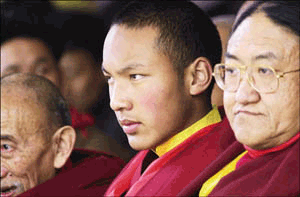 Ugyen Trinley Dorje (C), the 17th Karmapa, is flanked by Bhuddist priests from the Kagyu sect as he attends a cultural performance on the occasion of the 60th annivesary of the Dalai Lama's enthronement at Dharamsala's Main Temple, on Friday