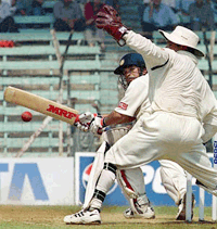 Sachin Tendulkar sweeps a delivery from Clive Eksteen  to the boundary as South African wicketkeeper Mark Boucher (R) looks on during the first day's play on Thursday at Wankhade Stadium in Bombay