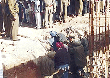 Fire Brigade personnel retrieve the body of one of the three labourers who were buried alive following the caving in of earth at the site of a showroom under construction in Sector 8 of Chandigarh on Monday