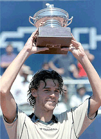 Brazil's Gustavo Kuerten lifts his trophy after winning the Santiago ATP tour with a 7-6, 6-3 victory over Mariano Puertas of Argentina at the San Carlos stadium in the Andes foothills, in Santiago, Chile on Sunday.