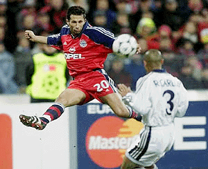 Bayern Munich's Hasan Salihamidzic (left) kicks the ball up in the air past Madrid's Carlos Roberto during the Group C UEFA Champions League soccer match Bayern Munich vs Real Madrid in Munich's Olympic Stadium on Wednesday.