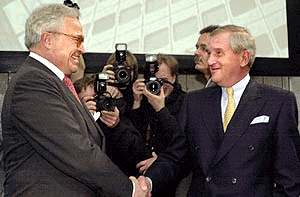 Chairman of the board of Deutsche Bank Rolf Breuer, left, shakes hands with the chairman of the board of Dresdner Bank Bernhard Walter, prior to a press conference where the two banks announced a merger of the rivals in Frankfurt, Germany on Thursday