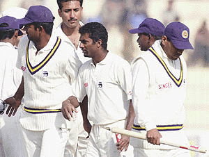 Sri Lankan off-spinner Muttiah Muralitharan (C) leaves the ground with other teammates after winning the 2nd Cricket Test against Pakistan in Peshawar on Thursday. 