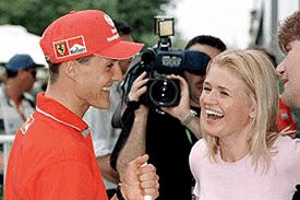 Former two-time world champion Michael Schumacher of Germany (L) shares a joke with his wife Corinna after crashing his Ferrari during the second practice session at the Australian Formula One Grand Prix in Melbourne on Friday