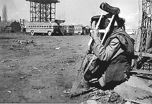 A handicapped person waiting hopelessly at a bus terminus during the general strike in Kashmir valley on Friday. 