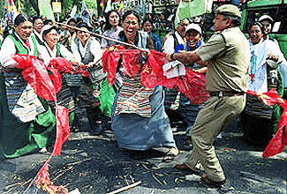 A policeman and Tibetan women tussle over a Chinese flag as the women try to burn the flags during a protest march in New Delhi, on Sunday to commemorate the 41st anniversary of Tibetan Womens Uprising Day against Chinese rule in Tibet