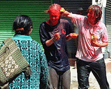 A local woman passes by watching as two young foreign women enjoy partaking in the ''Holi'' colour festival at a tourist centre in Kathmandu on Sunday
