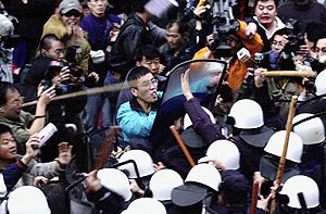 Angry protesters clash with riot police outside the ruling Kuomintang (KMT) party headquarters in Taipei on Sunday