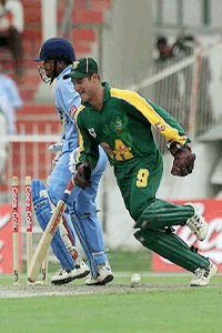 South Africa's wicket keeper Mark Boucher (foreground) celebrates as he runs past India's Sachin Tendulkar, after Tendulkar was runout during the India v South Africa cricket match at the Sharjah cricket ground, UAE on Monday