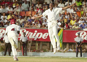 West Indies bowler Courtney Walsh (right) celebrates after Henry Olonga of Zimbabwe was caught out by Wavell Hinds (left) to break Kapil Dev's world record of test wickets taken for during the fourth day of the second test match at Sabina Park in Kingston, Jamaica on Monday