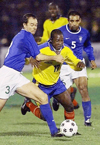 Colombia's Leonardo Favio, center, dribbles pass Brazil's Antonio Carlos, left, and Antonio Carlos during a South American group qualifier game for the World Cup 2002 in Bogota, on Tuesday