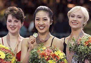 Michelle Kwan of the United States shows her gold medal surrounded by Russia's Irina Slutskaya (left) silver medal, and Maria Butruskaya, bronze medal, at the World Figure skating championship in Nice, on Saturday