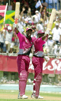 Chris Gayle (left) and Wavell Hinds (right) of the West Indies wave their bats to the crowd after Gayle hit a half century and Hinds a century against Zimbabwe during the second triangular one-day international series at Sabina Park in Kingston, Jamaica Sunday