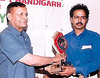 Mr S.K. Singh (IGP) presents a trophy to Shivraj Bharti Kaushal, dog trainer, in Sector 17, Chandigarh on Tuesday.	