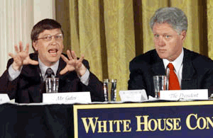 Bill Gates, CEO of Microsoft, answers a question as President Clinton looks on right, during the White House Conference on the "new economy" on Wednesday
