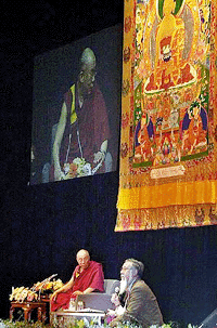 The Dalai Lama, left, accompanied by Tibetan staff of Liason Office of His Holiness The Dalai Lama in Japan Gyurme Wangda, sits in front of a mandala tapestry as he gives a lecture in Tokyo on Friday morning. The Tibetan spiritual leader is on a weeklong visit to Japan