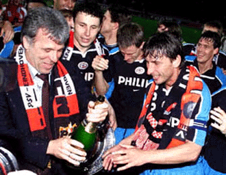 PSV Eindhoven coach Eric Gerets opens champagne accompanied by Belgiums Luc Nilis as they become Dutch champions after the match against Twente in Enschede on Friday