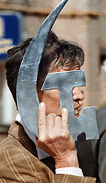 A man carries an iron hammer and a sickle symbol as he takes part in a May Day march in Kiev.  AFP