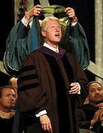 President Clinton receives a hood for a Honorary Doctorate of Public Service by Eastern Michigan University President William E. Shelton after his address at a graduation commencement ceremony at Eastern Michigan University in Ypsilanti, Sunday. In his remarks during commencement exercises, Clinton discussed the role of technology in our society and the additional safeguards needed to protect our privacy