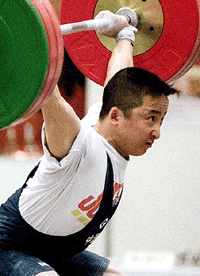 China's Shi Zhiyong stretches his arms to lift weights above his head on his way to win a gold medal in the men's 62-kg class in the Asian weightlifting championships at Osaka, western Japan, on Wednesday