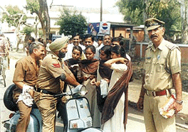 Girls students demand documents of the vehicle from a police official during an awareness campaign in Ambala City on Saturday