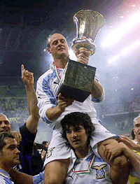 Lazio's Attilio Lombardo holds the Italian cup as he is carried on shoulders high by his teammate Fernando Couto of Portugal at the end of their match against Inter at the Milan San Siro stadium on Thursday