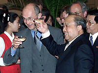 European Union Trade Commissioner Pascal Lamy (L) and China's Trade Minister Shi Guangsheng toast each other and the press after signing bilateral market opening trade agreements 19 May 2000 in Beijing, removing the last major obstacle to China's entry into the World Trade Organization (WTO).  The Sino-EU deal was eventually finalized after five days of dramatic and see-sawing negotiations this week in Beijing, the fourth round of talks between the two sides this year.   