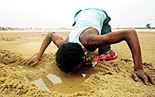 Nagendra, a labourer at a construction site, quenches his thirst from a water-hole dug on a dried-up river bed at Birbhum in West Bengal on Monday. With most of the water sources drying-up in the region, water-holes remain the sole source of drinking water for most of the local people