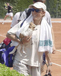 Martina Navratilova carries her dog Bina off the court after a training match for the Madrid Open tennis tournament, Madrid Monday
