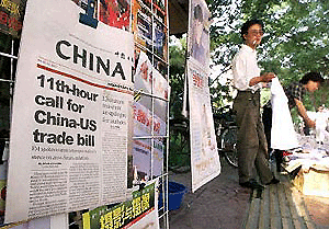 China�s leading English daily, headlining the US House of Representatives� vote for normalising trade ties with China, goes on sale in Beijing on Thursday as a street hawker sells knock-off designer brand T-shirts. 