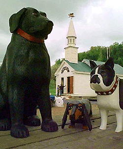 Workers put the finishing touches on the outside of artist Stephen Huneck's Dog Chapel in St. Johnsbury, Vt., on Friday. Huneck, the renowned Vermont folk artist known for his prints and sculptures of dogs, has built the chapel near his studio on Dog Mountain. At front are three of Huneck's dog sculptures