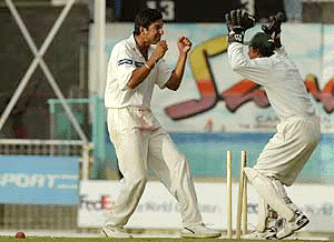 Wasim Akram of Pakistan (left) celebrates with wicket keeper Moin Khan