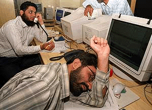 A broker rests in front of a terminal as trading remained suspended at the Karachi Stock Exchange on Tuesday, due to a number of crises including the continued fall in the market, payment problems and a traders strike across Pakistan