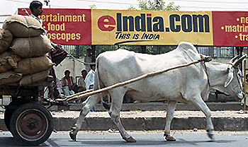 A bullock-driven cart rides past a bus stop billboard advertising one of India�s many Internet portals on Thursday in New Delhi. Though parts of the nation remain well below the poverty line, it is estimated that some $ 500 million was invested in dotcom start-ups in India in 1999