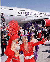 Sir Richard Branson, centre, chairman of Virgin Atlantic Airways, greets the crowd in Elvis garb as he exits the inaugural non-stop commercial flight from London to Las Vegas on Thursday, in Las Vegas.